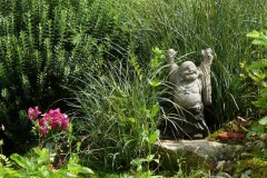 Lachender Buddha auf dem Steinbeet